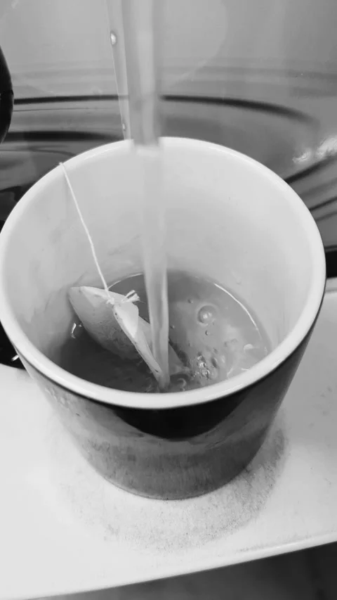 Macro 4K Vertical Video of Hot Water Pouring into a Mug with a Tea Bag 25fp Stock Footage 331793915