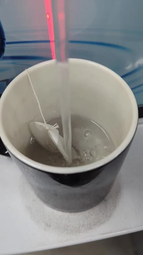 Macro 4K Vertical Video of Hot Water Pouring into a Mug with a Tea Bag 25fps Stock Footage 331793916