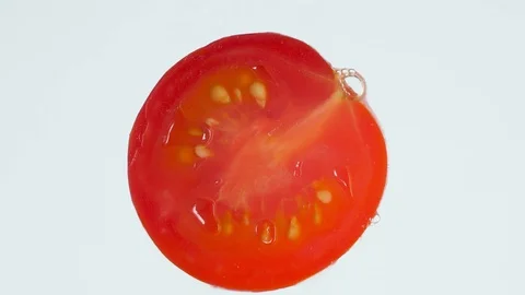 Macro 4k video of squeezing and exploding tomato piece. Making of tomato juice Stock Footage 125359471
