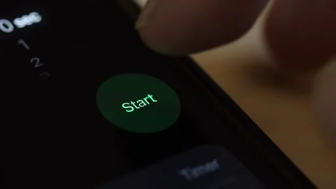 Macro 4K view of a finger pressing a green "Start" button on a black screen, act Stock Footage 342778010