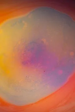 Macro abstract image of pastel liquid paint forming a soft swirling pool. Stock Photos