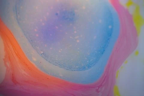 Macro abstract image of a soft blue liquid puddle surrounded by pink. 写真素材
