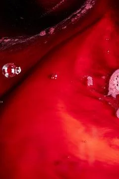 A macro abstract view of flowing red liquid with bubbles and dramatic shado.. Stock Photos