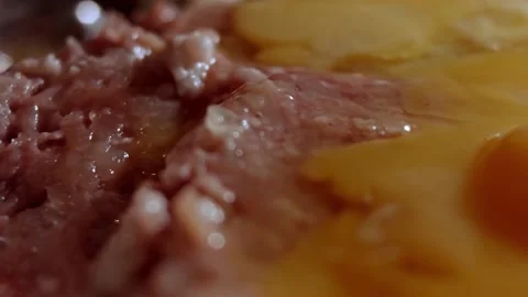 Macro of adding eggs to fresh minced meat in a metallic bowl. Cooking lunch at Stock Footage 143664669