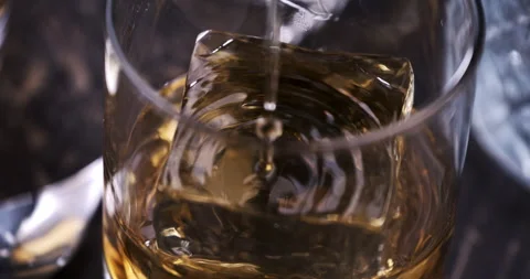Macro of aged bourbon whiskey poured in transparent glass with ice cubes Stock Footage 269383222