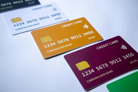 Macro angled diagonal row of multi-colored credit and debit cards on a whit.. Stock Photos