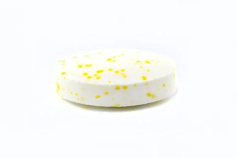 A macro background made of a single white candy with yellow spots. Foto stock