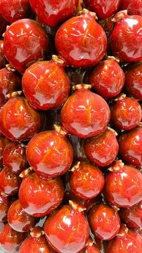 Macro background of sweet red glazed pomegranates with a vibrant glossy tex.. 库存照片