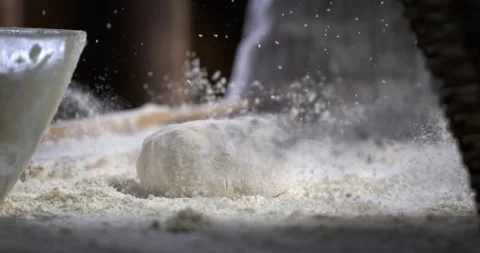 Macro of baker sprinkles flour on dough while making bread or pizza in bakery Stock Footage 269331273