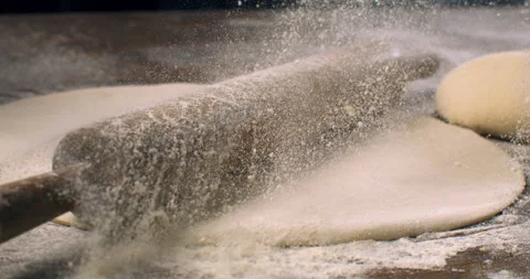Macro of baker sprinkles flour on rolling pin with raw dough while makes bread Stock Footage 268839463