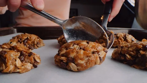 Macro baking sheet view of cookie dough scoops being placed on parchment paper Stock-Footage 129294155