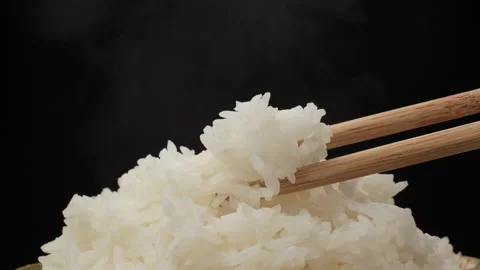 Macro Bamboo Chopsticks Picking Up Cooked White Rice Black Background Video stock 330942867