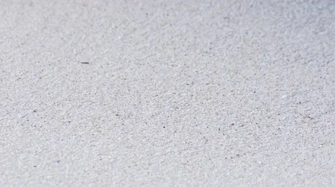 Macro of beach sand as clear ocean waves crash upon shore Stock Footage 58561296