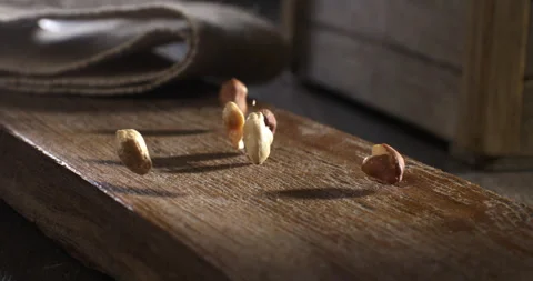 Macro of bio dried cleaned peanuts falling on table in kitchen of restaurant Stock-Footage 268802731