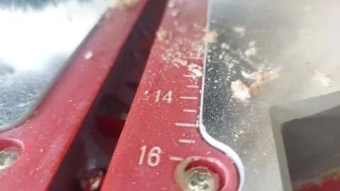 Macro of a black brush sweeping away sawdust from a red measurement scale on a s Stock Footage 335647282