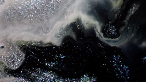 Macro of black glitter ink expanding through milky fluid Stock Footage 314299751