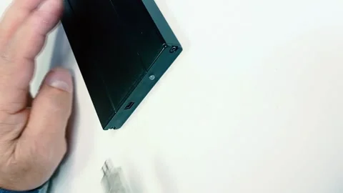 Macro of the black hard drive on the table and old man hand putting a white Stock Footage 142027255