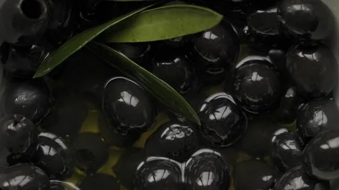Macro black pitted olives focus reveal on glistening pile Stock Footage 335028014