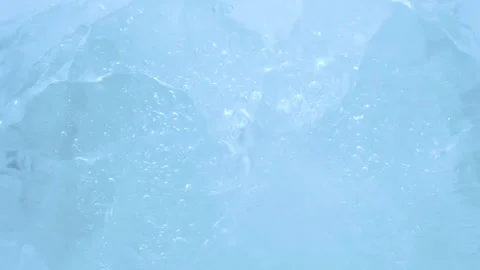 Macro blue broken ice texture with splashing water surface, drops and ripples Video stock 231394191