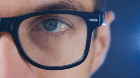 Macro blue eye of man in eyeglasses. Close up eye of businessman or student in Stock Footage 120570322