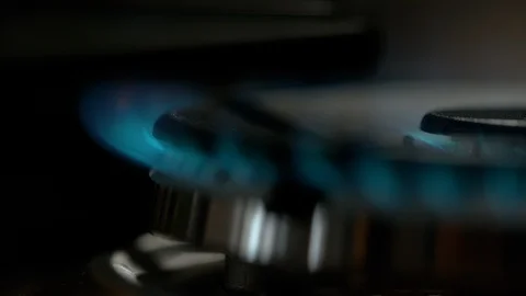 MACRO: Blue flames come out of a brand new stove burner after being turned on. Stock Footage 103553113
