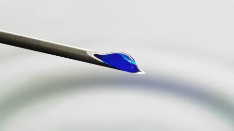 Macro Blue fluid dripping out of a Syringe needle. Biotech, Vaccine, CRISPR 스톡 동영상 133647513