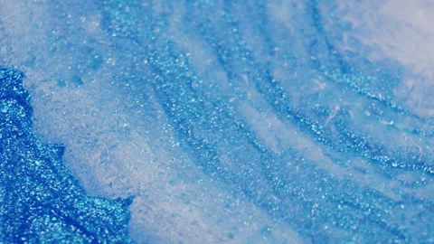 Macro of blue glitter ink rippling from injected air Stock Footage 314446110