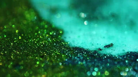Macro bokeh of shimmering glitter particles in vibrant fluid motion Stock Footage 331744479