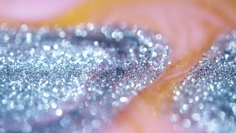 Macro bokeh of shimmering glitter particles in vibrant fluid motion Stock Footage 331748584