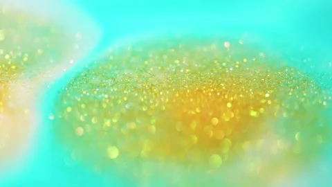 Macro bokeh of shimmering glitter particles in vibrant fluid motion Stock Footage 331753621