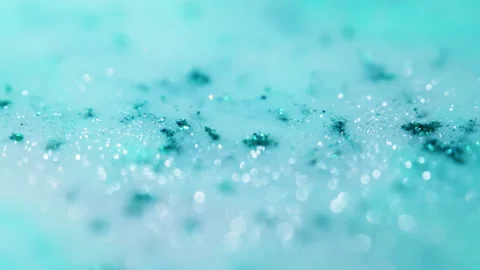 Macro bokeh of shimmering glitter particles in vibrant fluid motion Stock Footage 331755185