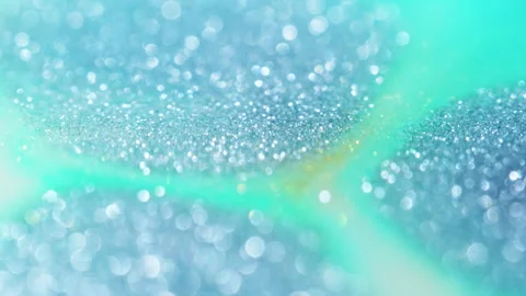 Macro bokeh of shimmering glitter particles in vibrant fluid motion Stock Footage 331758547