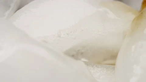 Macro brown soda pours over ice cube and carbonation fills the glass Stock Footage 127593350