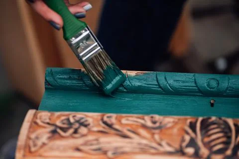 Macro on a brush in paint and the process of refreshing an old box with monog Foto stock