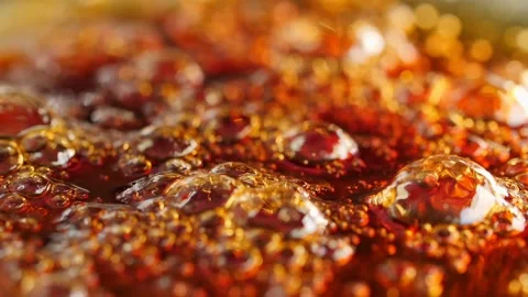 Macro bubbles of boiling caramel. Shallow depth of field, low angle. Slow motion Stock Footage 144181966