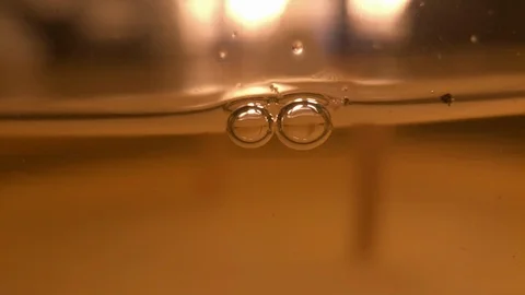 Macro Bubbles in candle Oil with flame burning, one pops Stock Footage 100613595