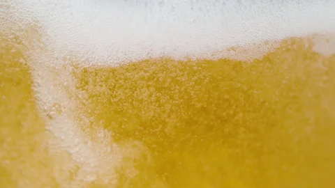 MACRO: Bubbling beer splashing around the glass as it gets poured from a tap. Stock Footage 166521787