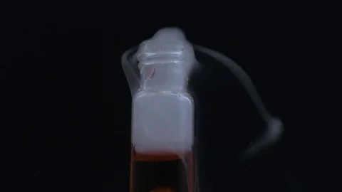 Macro bubbling smokey vial with red liquid Stock Footage 70706154