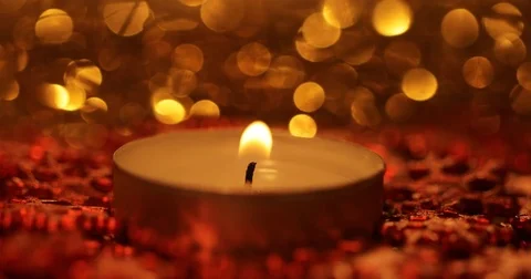 Macro of a burning candle with a lot of small red snowflakes in the evening Stock Footage 79970815