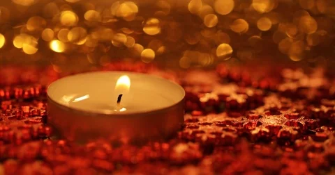 Macro of a burning candle with red snowflakes in the evening Stock Footage