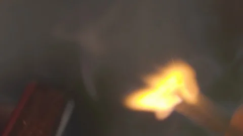 Macro, burning match in dark room. Male hands lighting up match on black Stock Footage 128900562