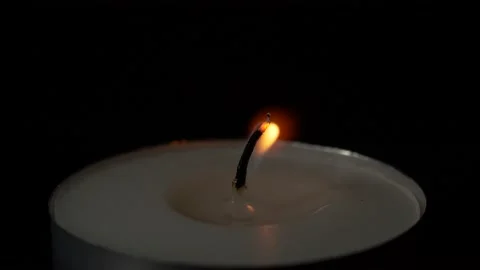 Macro burning small round candle flame isolated on black background, 4K video Stock Footage 143950207