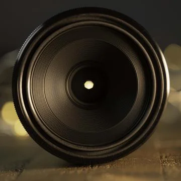 Macro camera lens, lights in background, wooden desk Stock Photos