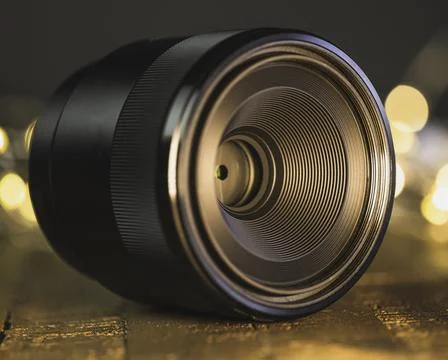 Macro camera lens, lights in background, wooden desk Stock Photos