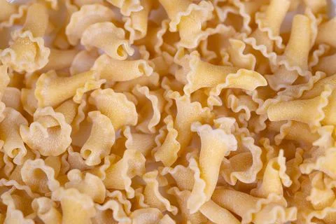 Macro campanelle pasta pattern, repetitive curved shapes forming textured bac Foto stock