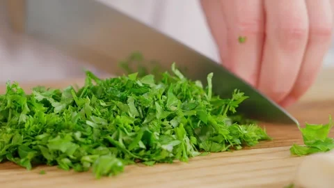 Macro, chef cuts greens with a sharp knife on a wooden board Stock Footage 270151421