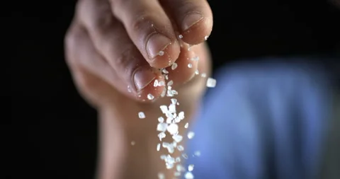 Macro of chef use salt on plate in kitchen Background at 1000fps. Stock Footage 269330633
