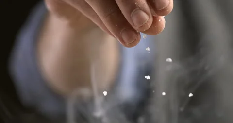 Macro of chef use salt on plate in kitchen Background at 1000fps. Stock Footage 269330758