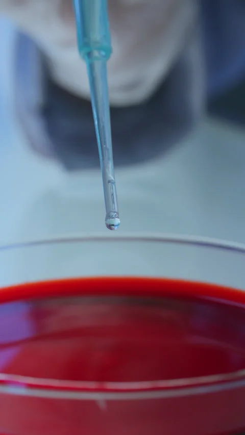 Macro of Chemist Pouring Liquid into Blood Sample with Pipette Stock Footage 337321165