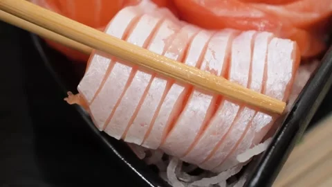 Macro of Chopsticks Picking Up Fresh Salmon Sashimi Slices Stock Footage 333600272